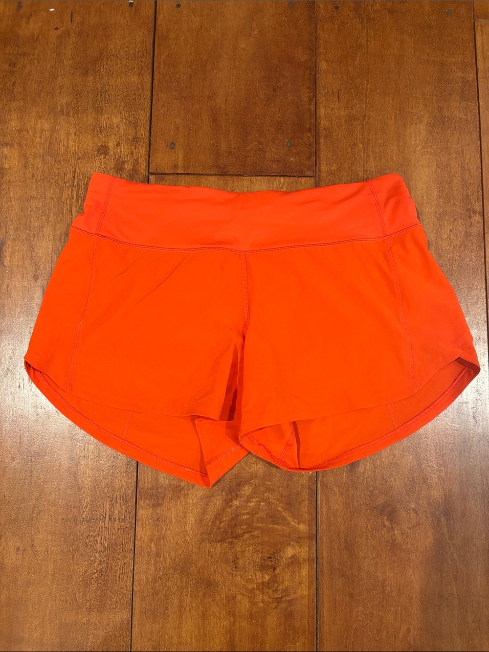 lululemon athletica women’s SolarOrange shorts. Mid rise 4 inch hem.